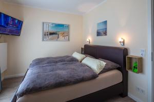 a bed in a bedroom with two pillows on it at Ostsee - Appartement Nr 151 "Hamborger Veermaster" im Strand Resort in Heiligenhafen +8 photos