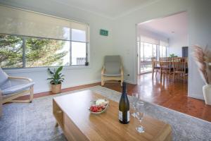 a living room with a bottle of wine on a table at Pete's on the Beach in Batemans Bay