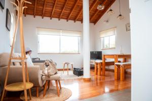 a living room with a woman sitting on a couch at Quinta das Almas in São Roque do Pico