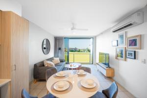 un salon avec une table et un canapé dans l'établissement Boutique Hamilton Stay Portside, à Brisbane
