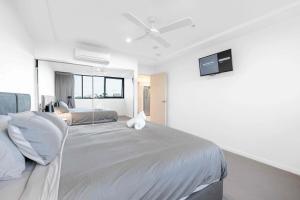 une chambre avec un grand lit avec une télévision au mur dans l'établissement Boutique Hamilton Stay Portside, à Brisbane