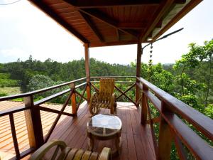 a wooden deck with chairs and a table on it at Alto de la Castilla in Constanza