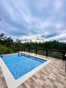 a swimming pool with blue water on a patio at Alto de la Castilla in Constanza