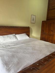 a bed with white sheets and a wooden head board at Alto de la Castilla in Constanza +7 photos