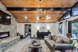 a living room with a couch and a fireplace at Honeybear Hideaways - Luxurious Modern 7BR Cabin with Indoor Pool, Game Room, Hot Tub & Fireplace in Sevierville