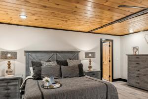 a bedroom with a bed with a wooden ceiling at Honeybear Hideaways - Luxurious Modern 7BR Cabin with Indoor Pool, Game Room, Hot Tub & Fireplace in Sevierville