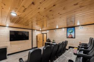 a conference room with chairs and a flat screen tv at Honeybear Hideaways - Luxurious Modern 7BR Cabin with Indoor Pool, Game Room, Hot Tub & Fireplace in Sevierville