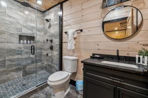 a bathroom with a toilet and a shower and a sink at Honeybear Hideaways - Luxurious Modern 7BR Cabin with Indoor Pool, Game Room, Hot Tub & Fireplace in Sevierville