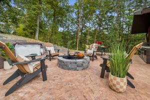 a patio with chairs and a fire pit and trees at Honeybear Hideaways - Luxurious Modern 7BR Cabin with Indoor Pool, Game Room, Hot Tub & Fireplace in Sevierville