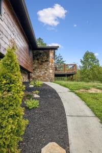 a stone house with a walkway next to a building at Honeybear Hideaways - Luxurious Modern 7BR Cabin with Indoor Pool, Game Room, Hot Tub & Fireplace in Sevierville