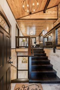 a staircase in a house with a wooden ceiling at Honeybear Hideaways - Luxurious Modern 7BR Cabin with Indoor Pool, Game Room, Hot Tub & Fireplace in Sevierville
