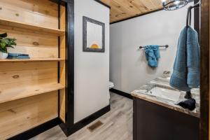 a bathroom with a sink and wooden walls at Honeybear Hideaways - Luxurious Modern 7BR Cabin with Indoor Pool, Game Room, Hot Tub & Fireplace in Sevierville