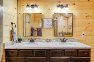 a bathroom with two sinks and two mirrors at Hot Tub, Fireplace and Views Sevierville Retreat! in Sevierville +27 photos