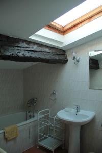 een badkamer met een wastafel, een bad en een dakraam bij Anges Gardiens in Villeneuve-lès-Béziers
