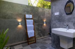 a bathroom with a sink and a shelf with towels at New! Mangalam house, Private plunge pool near beach in Trincomalee +32 photos