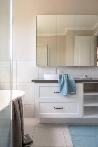 a white bathroom with a sink and a mirror at Bundjil Beach House Inverloch in Inverloch +20 photos