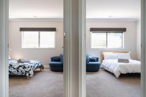 a bedroom with a bed and a bed and a chair at Bundjil Beach House Inverloch in Inverloch
