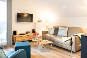 ein Wohnzimmer mit einer Couch und einem Tisch in der Unterkunft Ostsee - Appartement Nr 19 "Sonnenzauber" im Strand Resort in Heiligenhafen