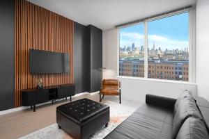 霍博肯Exclusive 1BR Apt with NYC View and Pool的带沙发和大窗户的客厅