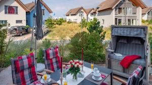 einen Tisch und Stühle auf einer Terrasse mit einem Bett in der Unterkunft Ostsee - Appartement Nr 181 "Uferschwalbe" im Strand Resort in Heiligenhafen