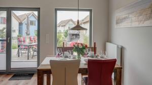 ein Esszimmer mit einem Tisch und einer Vase aus Blumen in der Unterkunft Ostsee - Appartement Nr 181 "Uferschwalbe" im Strand Resort in Heiligenhafen