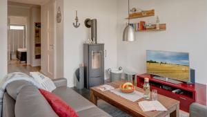 ein Wohnzimmer mit Couch und Fernseher in der Unterkunft Ostsee - Appartement Nr 181 "Uferschwalbe" im Strand Resort in Heiligenhafen