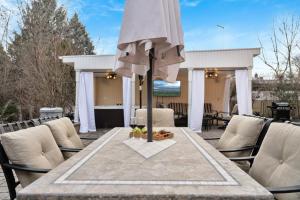 a table with an umbrella on a patio at Fire and Fun Luxe Stay w Pool Hot Tub and Game Room in Linden