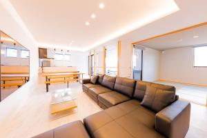 ein Wohnzimmer mit Sofa und Tisch in der Unterkunft AMBER Yufuin in Yufu