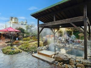 a garden with a fire pit and a building at Sagayamato Onsen Hotel Amandi in Saga