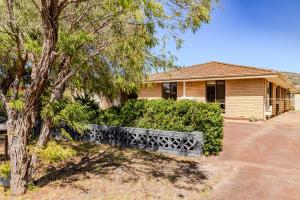 a house with a fence in front of a tree at Morning Light Beach House - by the BnB Collection in Albany