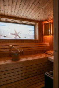 eine Holzsauna mit einem Seestern im Fenster in der Unterkunft Ostsee - Reetdachhaus Nr 42 "Waterkant" im Strand Resort in Heiligenhafen