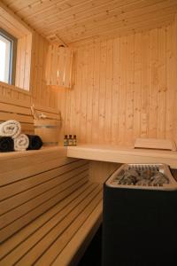 eine Sauna mit Badewanne und Herd darin in der Unterkunft Ostsee - Reetdachhaus Nr 42 "Waterkant" im Strand Resort in Heiligenhafen + 8 Fotos