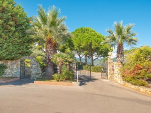 a gate with palm trees next to a stone wall at Appartements mit Veranda, Andora in Marina di Andora