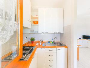 a white kitchen with white cabinets and a sink at Appartements mit Veranda, Andora in Marina di Andora +14 photos