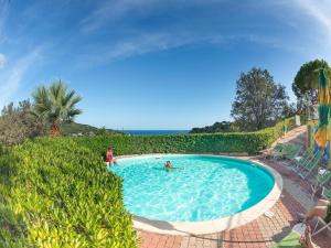 two people in a swimming pool in a resort at Appartements mit Veranda, Andora in Marina di Andora