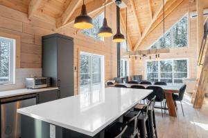 a kitchen and dining room with a large white counter top at ÔShack - spa - billiard in Saint Come