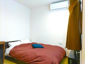 a bedroom with a bed with a red comforter at PREMIUM TOJI - Vacation STAY 28868v in Kyoto