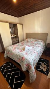 Bett in einem Zimmer mit zwei Paar Schuhen in der Unterkunft Solar Campos do Jordão - Perfeita para casal e Família in Campos do Jordão