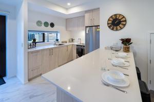 クライストチャーチにあるTuam Street delight 4 bed 4 bath with Carparkのキッチン(皿付きの白いカウンター付)