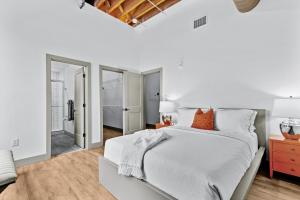 1 dormitorio blanco con 1 cama grande con almohadas de color naranja en Stunning 5 Star Stay! Guest Favorite with River View, en Saint Louis