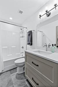 Un baño blanco con lavabo e inodoro. en Stunning 5 Star Stay! Guest Favorite with River View, en Saint Louis