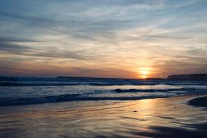 a sunset on a beach with the ocean at Apartamento en Barbate in Barbate