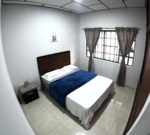 una camera da letto con un letto con una coperta blu di Apartamento Familiar, Brrio Olimpico! a Villavicencio