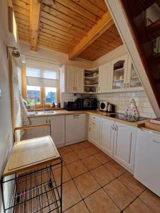 a large kitchen with white cabinets and a window at Family friendly house with a parking space Varazdin, Zagorje - 22470 in Kućan Marof