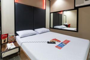 a bedroom with a large white bed with two mirrors at Hotel Sogo Santa Mesa in Manila