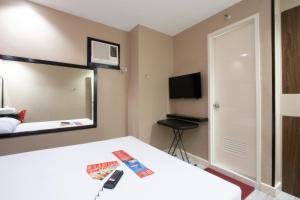 a hotel room with a bed and a mirror at Hotel Sogo Santa Mesa in Manila