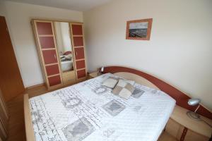 a bedroom with a bed with a white comforter at Ostseeglück App9 in Zingst +16 photos