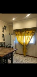 a dining room with a yellow curtain on a window at Dreams in La Plata