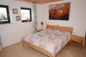 海利根港Ferienwohnung Strandperle的卧室里有一张床，墙上挂着一幅画