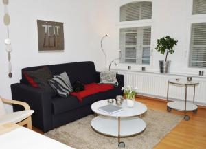 a living room with a black couch and a table at Kunst&Handwerk in Eckernförde